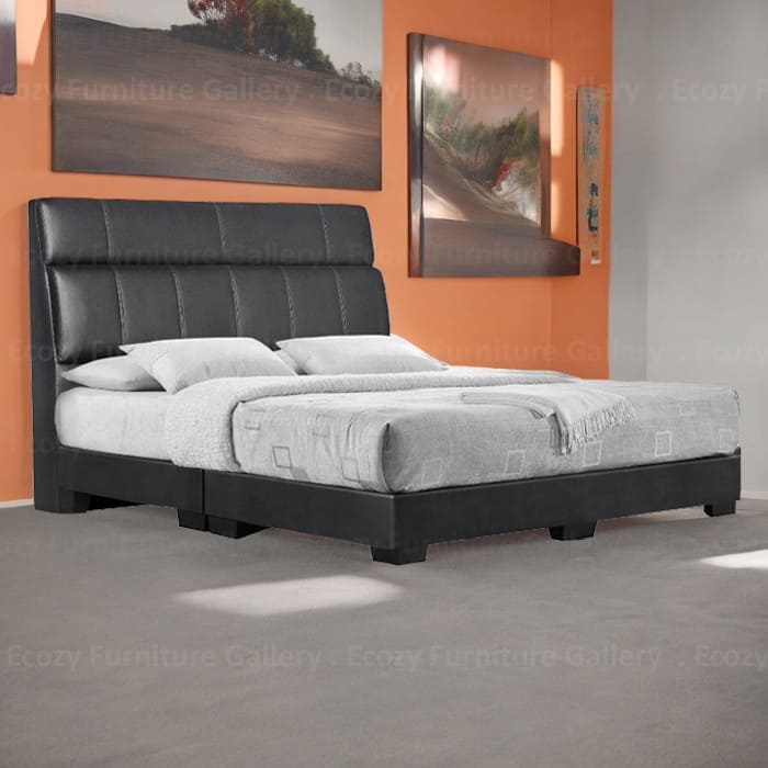 A modern divan bed upholstered in black color faux leather, it is features a sleek design with a cushioned headboard