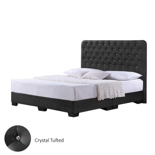 A grey upholstered bed frame with a slightly curved, tufted crystal headboard and black legs