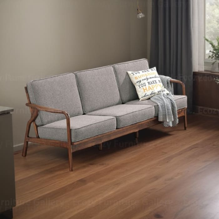 Wooden Sofa with a light brown fabric cushion, featuring wooden armrests and a sleek design, set in a cozy living room with warm lighting and wooden flooring